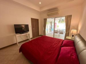 乔木提恩海滩View Talay Villas - Luxury 2BR pool villa nr beach - VTV 86的一间卧室配有一张红色大床和一台电视