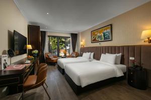 河内San Palace Hotel & Spa的酒店客房配有两张床和一张书桌