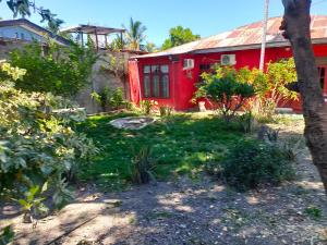 帝力Casa Minha Backpackers Hostel的前面有花园的红色房子