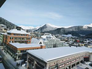 达沃斯Holiday Apartment Davos Residence的建筑物屋顶上积雪的城市