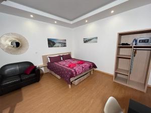 尼斯Residence Akantha的一间卧室配有一张床和一张黑色皮椅