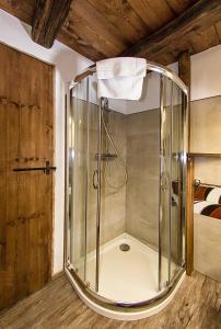 普拉吉拉托Agriturismo Rivet d'Or的一间设有床铺的客房内的玻璃淋浴间