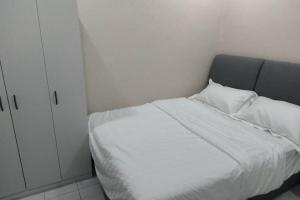 万挠Embun Bayu Musliim homestay的卧室配有白色的床和橱柜。