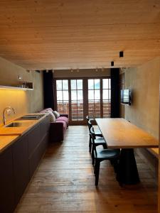 瓦尔迪登特罗YETI Design mountain apartments的一间带木桌的厨房和一间餐厅