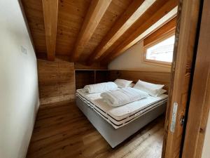瓦尔迪登特罗YETI Design mountain apartments的小型客房的一张床位,设有木制天花板
