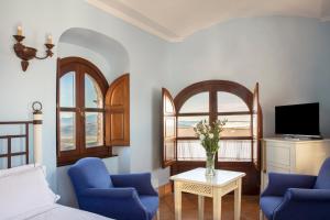 弗龙特拉堡Hotel Tugasa Castillo de Castellar的客厅配有2把蓝色椅子和电视