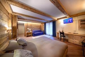 阿帕里卡Hotel Ambrosini的一间卧室配有一张大床和一张蓝色的沙发