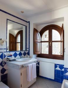 弗龙特拉堡Hotel Tugasa Castillo de Castellar的蓝色和白色的浴室设有水槽和镜子