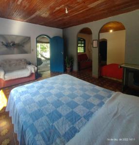 卢米亚Hospedaria e Camping Quintal do Mundo的一间位于客房内的卧室,配有蓝色和白色的床