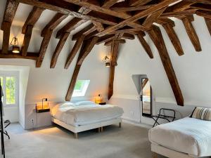 卢瓦尔河畔蒙路易Le Clos du Roc的一间卧室设有两张床和木梁。