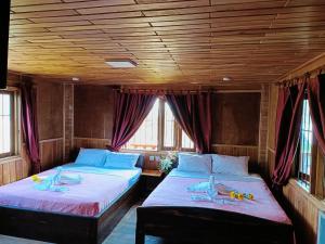 贡布Sunshine Hotel Kampot的配有窗户的火车室内的两张床