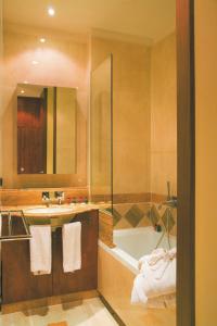 巴涅尔-德吕雄埃蒂尼酒店的带浴缸、水槽和镜子的浴室