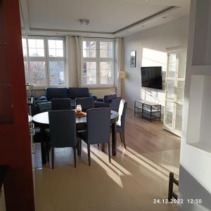 格但斯克Apartament Długa 35的客厅配有桌椅和沙发