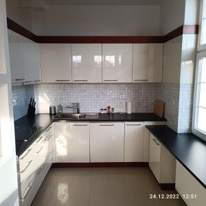 格但斯克Apartament Długa 35的白色的厨房配有白色橱柜和水槽