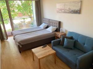 派尔努Sunny Aisa Apartment的一间卧室配有一张床和一张蓝色的沙发