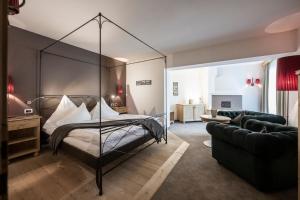 塞尔瓦迪加尔代纳山谷阿卡迪亚酒店 - 山地之家成人酒店的一间带天蓬床的卧室和一间客厅