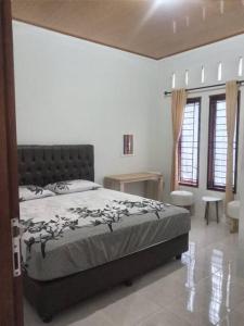 PanjaitanBatajaya Cottage的卧室配有床、桌子和窗户。