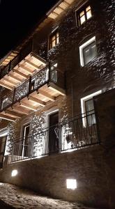 蒂米萨那Casagli Luxury Suites的一座砖砌建筑,设有阳台和灯光