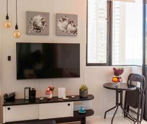 开普敦Flamingo Sea Point Sea View Luxury Best Position 1 Bedroom Apartment Queen Size Bed & Inverter For TV的客厅配有平面电视和桌子。