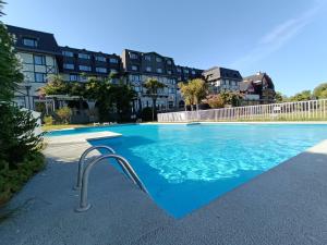 普孔Hotel Enjoy Pucon的一个蓝色的游泳池以及背景建筑