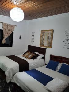 里奥班巴Casa de Mármol的一间卧室配有两张床和吊灯。