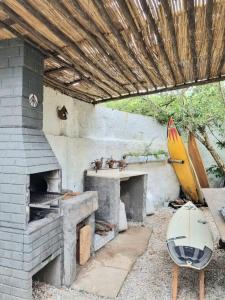 乌巴图巴Yabás Praia的室外厨房配有砖炉和冲浪板