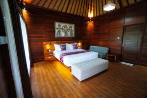 乌布Adil Villa & Resort的一间卧室配有一张床和一把椅子