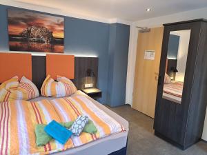 贝希特斯加登阿尔皮纳酒店的一间卧室配有一张带色彩缤纷枕头的大床