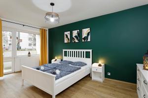 弗罗茨瓦夫Na zielonym Widoku的卧室配有白色的床和绿色的墙壁