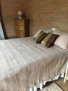 圣安东尼奥-杜皮尼亚尔Estância Liberdade的一间卧室配有带枕头的床和砖墙