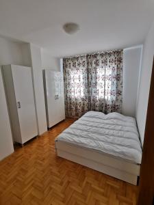 斯特鲁米察007 Apartments - TC Global, Strumica, Macedonia的卧室配有白色的床和窗户。