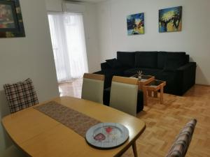 斯特鲁米察007 Apartments - TC Global, Strumica, Macedonia的客厅配有桌子和黑色沙发