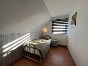 StevensweertAan de Kis的阁楼上的卧室设有一张床,设有窗户