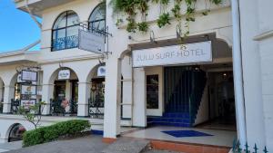 塔马林多Zulu Surf Hotel Tamarindo的商店前方有杂物旅馆标志
