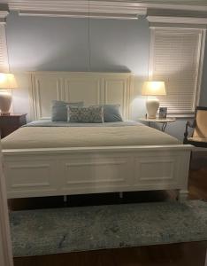Smiths Point SettlementThe Blue Inn Family Vacation Rental的一间卧室配有一张带两盏灯的大型白色床。