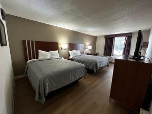 钱伯斯堡Econo Lodge Inn & Suites的酒店客房设有两张床和一台平面电视。