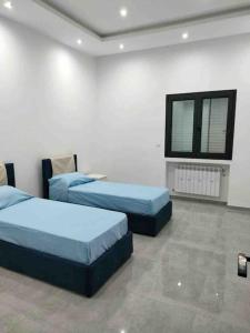 突尼斯Appartamento di lusso in Tunisia的客房设有两张床和一台墙上的电视。
