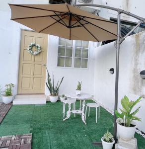 宜力Helena’s Studio Suite Gerik的一个带桌子和遮阳伞的庭院