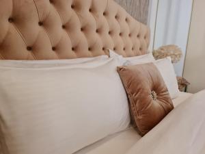 锡卜Amazing Villa in Muscat的一张带棕色软垫床头板和枕头的床