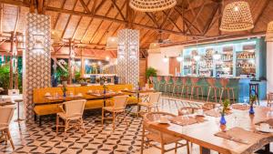 福尔图纳Nayara Gardens的一间带桌椅的餐厅和一间酒吧