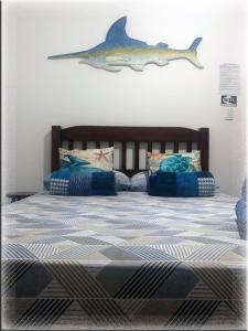 阿拉亚尔-杜卡布Suíte Trilha do Sol 2的卧室配有一张墙上有鲨鱼的床