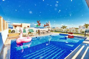 赫尔格达Hurghada Sahl Hasheesh sea-view Villa with private pool的度假酒店内带充气火烈鸟的游泳池