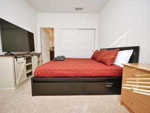 萨克拉门托Luxury 3 Bedroom House Near Sacramento Airport的一间卧室配有红色的床和一台平面电视