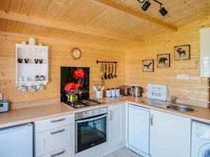 StoodleighNirvana的厨房配有白色橱柜和炉灶烤箱。