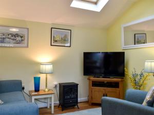 BarhamThe Annexe的客厅配有平面电视和壁炉。