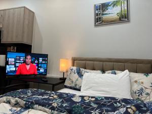 伊灵Belvue Serviced Apartment - Ealing Broadway的一间卧室配有一张床和一张书桌及电视