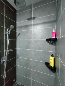 怡保Studio in Sunway Onsen @ Lost World of Tambun for 4的浴室设有黑色瓷砖淋浴。