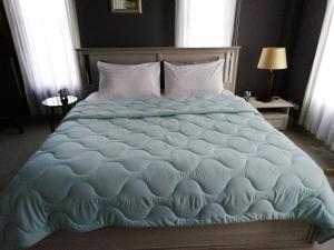 功孟海滩Klong Muang Beach Apartment的一间卧室配有一张带蓝色棉被的大床