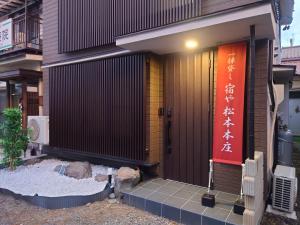 松本Yadoya Matsumoto Honjo - Vacation STAY 13372v的一座建筑,上面有红色的门和标志
