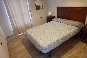 巴达霍斯En el corazón de la ciudad的一间卧室配有一张带木制床头板的床
